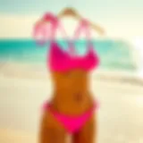 A vibrant bright pink tankini displayed on a beach background with sunlight reflecting off the water.